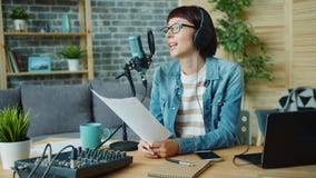 Slow motion of young lady reading in microphone holding paper with speech stock video footage Slow motion of young lady reading in microphone holding paper with speech stock video footage