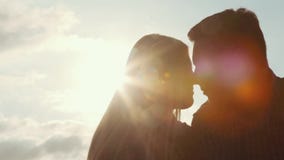 Sluit mening van verdonkeren omhoog silhouet van een gelukkig paar die van een vertrouwelijk ogenblik wat betreft hun neuzen op h stock footage Sluit mening van verdonkeren omhoog silhouet van een gelukkig paar die van een vertrouwelijk ogenblik wat betreft hun neuzen op h stock footage