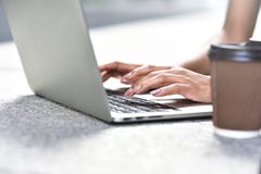 Sluit omhoog foto van vrouwenhanden typend op laptop bij straat stock afbeelding Sluit omhoog foto van vrouwenhanden typend op laptop bij straat stock afbeelding