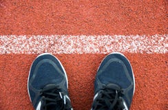 Sluit omhoog loopschoenen op renbaan Witte Lijnen bij sportstadion stock fotografie Sluit omhoog loopschoenen op renbaan Witte Lijnen bij sportstadion stock fotografie