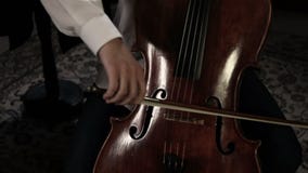 Sluit omhoog pan van een cellospeler die wordt geschoten Sluit omhoog pan van een cellospeler die wordt geschoten