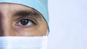 Sluit omhoog portret van een chirurg of een arts met masker en een hoofdtelefoon klaar voor verrichting in het ziekenhuis of klin stock video Sluit omhoog portret van een chirurg of een arts met masker en een hoofdtelefoon klaar voor verrichting in het ziekenhuis of klin stock video