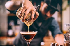Sluit omhoog van barmanhand die alcoholische cocktail in martini-glas gieten royalty-vrije stock foto's Sluit omhoog van barmanhand die alcoholische cocktail in martini-glas gieten royalty-vrije stock foto's