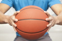 Sluit omhoog van de jonge mens, midsection, die een basketbal houden Royalty-vrije Stock Afbeeldingen Sluit omhoog van de jonge mens, midsection, die een basketbal houden Royalty-vrije Stock Afbeeldingen