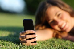 Sluit omhoog van een gelukkige hand van het tienermeisje gebruikend een slimme telefoon op het gras royalty-vrije stock foto's Sluit omhoog van een gelukkige hand van het tienermeisje gebruikend een slimme telefoon op het gras royalty-vrije stock foto's