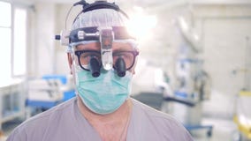 Sluit omhoog van een gezicht van een arts die glazen, een speciaal hulpmiddel en een masker dragen Professioneel artsenportret stock video Sluit omhoog van een gezicht van een arts die glazen, een speciaal hulpmiddel en een masker dragen Professioneel artsenportret stock video