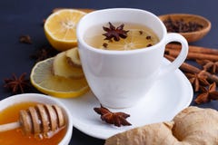 Sluit omhoog van een kop met gemberthee en ingrediënten op donkere lijst royalty-vrije stock afbeelding Sluit omhoog van een kop met gemberthee en ingrediënten op donkere lijst royalty-vrije stock afbeelding