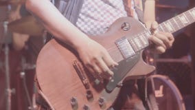 Sluit omhoog van een mens die een gitaar spelen tijdens levende prestaties met de veranderende lichten van het kleurenstadium stock videobeelden Sluit omhoog van een mens die een gitaar spelen tijdens levende prestaties met de veranderende lichten van het kleurenstadium stock videobeelden