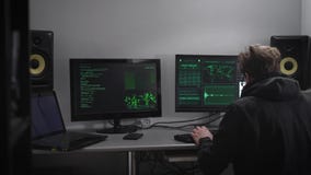 Sluit omhoog van een spion met smartwatch en mobiele telefoonzitting bij de lijst met computermonitors Hakker die proberen te ber stock videobeelden Sluit omhoog van een spion met smartwatch en mobiele telefoonzitting bij de lijst met computermonitors Hakker die proberen te ber stock videobeelden
