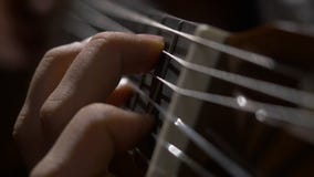 Sluit omhoog van gitaristhand spelend akoestische gitaar Sluit omhoog geschoten van een mens met zijn vingers op de lijstwerken v stock afbeeldingen Sluit omhoog van gitaristhand spelend akoestische gitaar Sluit omhoog geschoten van een mens met zijn vingers op de lijstwerken v stock afbeeldingen