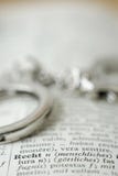 Sluit omhoog van handcuffs op woordenboek stock afbeeldingen Sluit omhoog van handcuffs op woordenboek stock afbeeldingen
