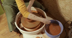 Sluit omhoog van handen die klei werken aan pottenbakkers` s wiel, close-upmening stock footage Sluit omhoog van handen die klei werken aan pottenbakkers` s wiel, close-upmening stock footage