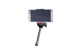Sluit omhoog van het lege smartphonescherm met zwarte die selfiestok op witte achtergrond wordt geïsoleerd royalty-vrije stock foto Sluit omhoog van het lege smartphonescherm met zwarte die selfiestok op witte achtergrond wordt geïsoleerd royalty-vrije stock foto