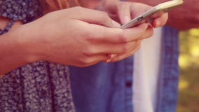 Sluit omhoog van jongeren gebruikend smartphones stock footage Sluit omhoog van jongeren gebruikend smartphones stock footage