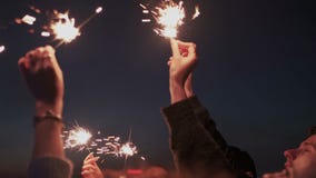 Sluit omhoog van vriendenhanden met de lichten van Bengalen of het fonkelen Zij heffen handen aan hemel op, die op het stadsdak b stock video Sluit omhoog van vriendenhanden met de lichten van Bengalen of het fonkelen Zij heffen handen aan hemel op, die op het stadsdak b stock video