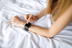 Sluit omhoog vrouwelijke handen met slim horloge op witte linnenachtergrond Stock Afbeeldingen Sluit omhoog vrouwelijke handen met slim horloge op witte linnenachtergrond Stock Afbeeldingen