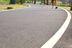 Slutet upp jordyttersida av staden parkerar trottoar med varmt ljus i aftonen och gjorde suddig en man som joggar på en väg arkivbilder Slutet upp jordyttersida av staden parkerar trottoar med varmt ljus i aftonen och gjorde suddig en man som joggar på en väg arkivbilder