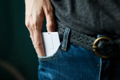 Slutet upp kvinnahanden som griper ett vitt kort i jeans, stoppa i fickan royaltyfri fotografi Slutet upp kvinnahanden som griper ett vitt kort i jeans, stoppa i fickan royaltyfri fotografi