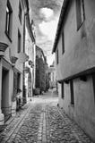 Smal gata med medeltida europeisk arkitektur- och kullerstentrottoar, gamla Riga fotografering för bildbyråer Smal gata med medeltida europeisk arkitektur- och kullerstentrottoar, gamla Riga fotografering för bildbyråer