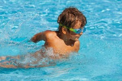 Small boy with water sport goggles swims in pool Stock Images Small boy with water sport goggles swims in pool Stock Images