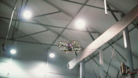 Small copter flies under the ceiling indoors. Drone flying over the floor. stock images Small copter flies under the ceiling indoors. Drone flying over the floor. stock images