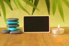 Small empty slate in width to write a message posed on the bamboo floor with gray and blue stones columns in the lifestyle Zen wit Stock Images Small empty slate in width to write a message posed on the bamboo floor with gray and blue stones columns in the lifestyle Zen wit Stock Images