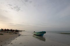 Small fishing boat reflecting in sunset light on Nilaveli beach in Trincomalee Sri Lanka royalty free stock image Small fishing boat reflecting in sunset light on Nilaveli beach in Trincomalee Sri Lanka royalty free stock image