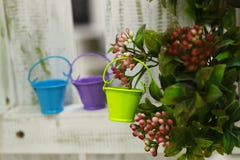 Colorful miniature garden watering can on a background of bushes stock photo Colorful miniature garden watering can on a background of bushes stock photo