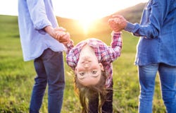 A small girl with her senior grandparents having fun outside in nature at sunset. Royalty Free Stock Photos A small girl with her senior grandparents having fun outside in nature at sunset. Royalty Free Stock Photos