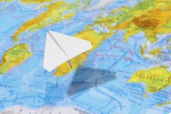 Small paper airplane over a geographical map of the world. selective focus. stock image Small paper airplane over a geographical map of the world. selective focus. stock image