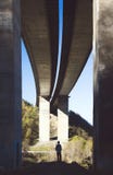 Small person under a big bridge