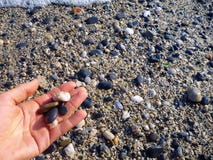 small-stones-hand-beach-some-78560608.jpg