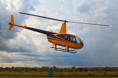 A small yellow helicopter takes off. Storm clouds in the background. A small private airfield in Zhytomyr, Ukraine royalty free stock images A small yellow helicopter takes off. Storm clouds in the background. A small private airfield in Zhytomyr, Ukraine royalty free stock images