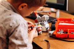 Smart boy dressed in gray shirt makes a robot from the robotic constructor at the desk in the School of Robotics royalty free stock images Smart boy dressed in gray shirt makes a robot from the robotic constructor at the desk in the School of Robotics royalty free stock images