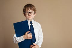 Smart boy in elegant suit and glasses sitting on a Chesterfield sofa with a Tablet paper. Educational concept. Children royalty free stock photo Smart boy in elegant suit and glasses sitting on a Chesterfield sofa with a Tablet paper. Educational concept. Children royalty free stock photo