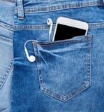 smartphone blanco con los auriculares en el bolsillo trasero de tejanos fotografía de archivo libre de regalías smartphone blanco con los auriculares en el bolsillo trasero de tejanos fotografía de archivo libre de regalías