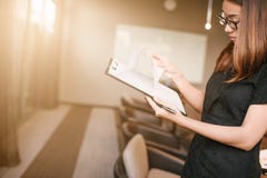 Smartphone d'affaires et documents womanlooking de se tenir dans des mains Bureau de grenier de l'espace ouvert, jeune femme d'af Image stock Smartphone d'affaires et documents womanlooking de se tenir dans des mains Bureau de grenier de l'espace ouvert, jeune femme d'af Image stock
