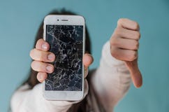 Smartphone de cristal quebrado de la pantalla a disposición de la mujer trastornada foto de archivo Smartphone de cristal quebrado de la pantalla a disposición de la mujer trastornada foto de archivo