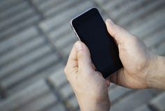 Smartphone i manliga händer, bästa sikt, utomhus royaltyfri fotografi Smartphone i manliga händer, bästa sikt, utomhus royaltyfri fotografi