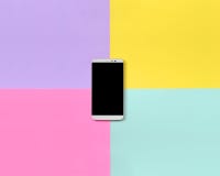 Smartphone moderne avec l'écran noir sur le fond de texture du papier bleu de mode, jaune, violet et rose en pastel de couleurs d photos stock Smartphone moderne avec l'écran noir sur le fond de texture du papier bleu de mode, jaune, violet et rose en pastel de couleurs d photos stock