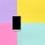 Smartphone moderno con lo schermo nero sul fondo di struttura della carta blu di modo, gialla, viola e rosa pastello di colori in immagini stock libere da diritti Smartphone moderno con lo schermo nero sul fondo di struttura della carta blu di modo, gialla, viola e rosa pastello di colori in immagini stock libere da diritti
