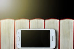 Smartphone sur le fond des livres Fond foncé, l'espace de copie Concept : livres et instruments électroniques photo stock Smartphone sur le fond des livres Fond foncé, l'espace de copie Concept : livres et instruments électroniques photo stock