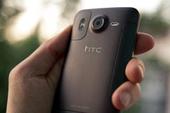Smartphone van de de greepHTC Wens HD van de hand stock fotografie Smartphone van de de greepHTC Wens HD van de hand stock fotografie