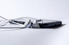 Smartphone z hełmofonami dla słuchać muzyka fotografia stock Smartphone z hełmofonami dla słuchać muzyka fotografia stock