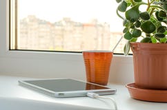Smartphone και πράσινο λουλούδι σε ένα βάζο στο παράθυρο στοκ φωτογραφίες με δικαίωμα ελεύθερης χρήσης Smartphone και πράσινο λουλούδι σε ένα βάζο στο παράθυρο στοκ φωτογραφίες με δικαίωμα ελεύθερης χρήσης