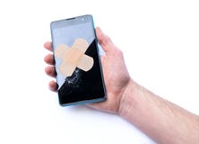 Smartphone με τη ραγισμένη επίδειξη υπό εξέταση και το συγκολλητικό επίδεσμο έννοια των τηλεφώνων επισκευής στοκ φωτογραφία με δικαίωμα ελεύθερης χρήσης Smartphone με τη ραγισμένη επίδειξη υπό εξέταση και το συγκολλητικό επίδεσμο έννοια των τηλεφώνων επισκευής στοκ φωτογραφία με δικαίωμα ελεύθερης χρήσης