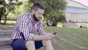 Smartphone ξεφυλλίσματος ατόμων, που κάθεται στα σκαλοπάτια Ολισθαίνων ρυθμιστής και παν πυροβολισμός φιλμ μικρού μήκους Smartphone ξεφυλλίσματος ατόμων, που κάθεται στα σκαλοπάτια Ολισθαίνων ρυθμιστής και παν πυροβολισμός φιλμ μικρού μήκους