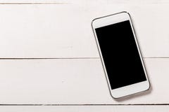 Smartphone στο ξύλινο υπόβαθρο σύστασης Τοπ όψη στοκ εικόνα με δικαίωμα ελεύθερης χρήσης Smartphone στο ξύλινο υπόβαθρο σύστασης Τοπ όψη στοκ εικόνα με δικαίωμα ελεύθερης χρήσης