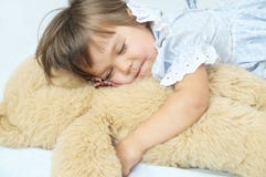 Smiley feliz el dormir de la niña con el oso de peluche Imagenes de archivo Smiley feliz el dormir de la niña con el oso de peluche Imagenes de archivo