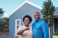 Smiling African couple standing with keys to their new home royalty free stock photos Smiling African couple standing with keys to their new home royalty free stock photos